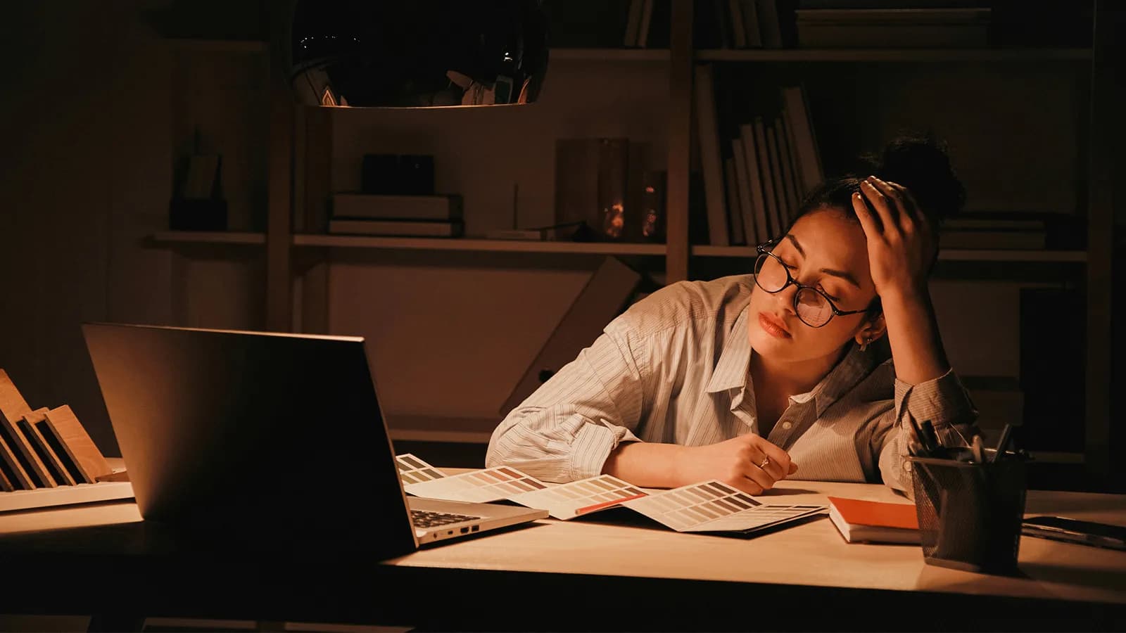 Mujer cansada trabajando de noche en su escritorio